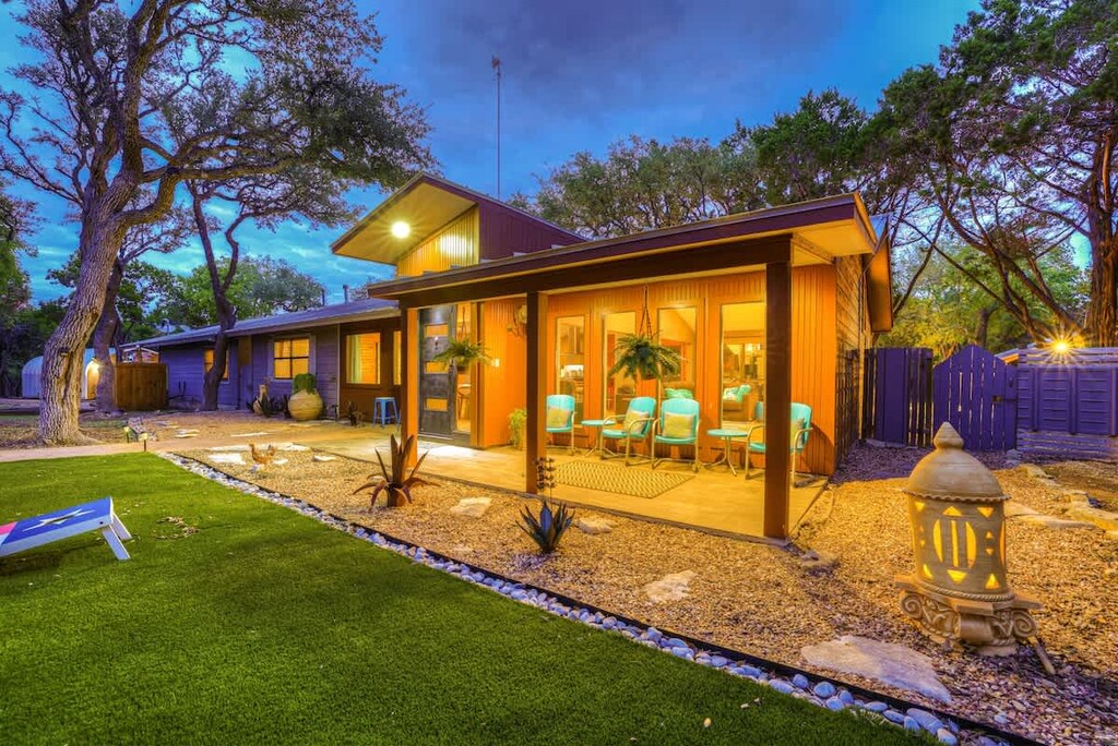 The front patio offers a cozy retreat with chic seating, providing a perfect vantage point to admire the front lawn—a serene setting blending comfort and natural beauty in perfect harmony.