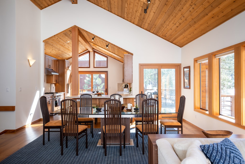 Alternative view from dining area showing well-equipped gourmet kitchen (remodeled in 2021) w/ breakfast counter and a sliding glass door leading to the deck off the kitchen and dining area