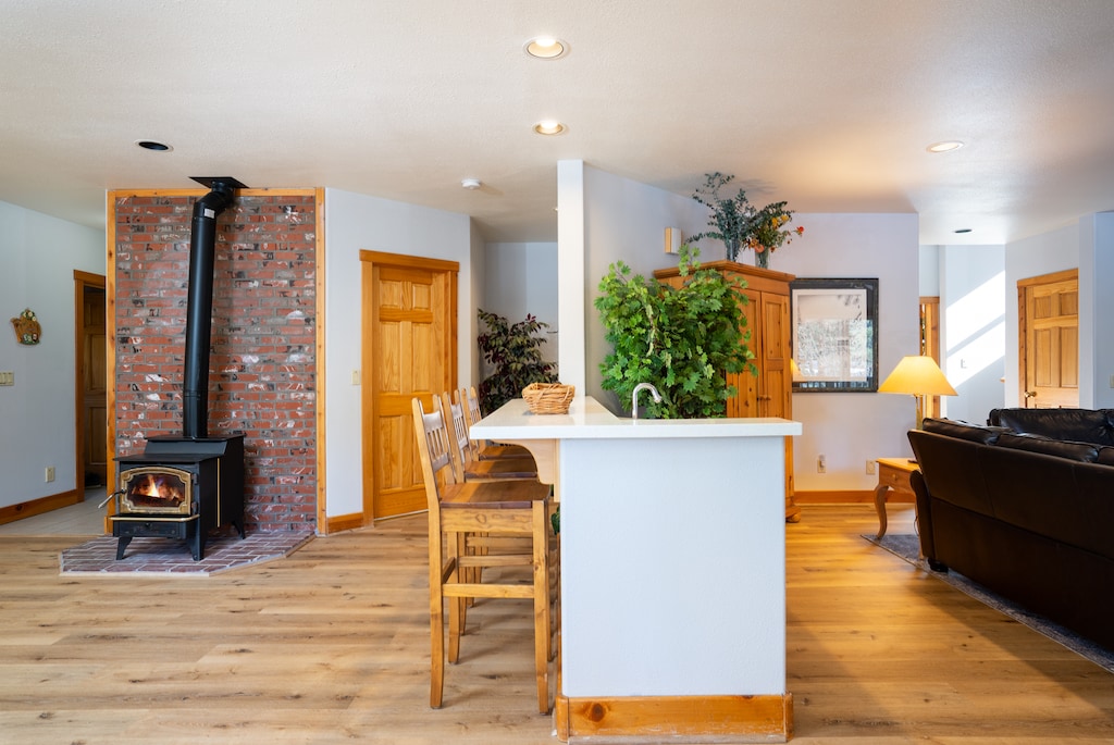 gas stove is anchored between the kitchen and wet bar providing warmth to the open floor plan, full bath, laundry room and access to garage are steps away