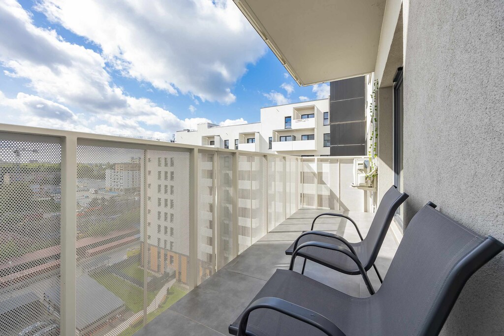 Spacious balcony with outdoor furniture. 