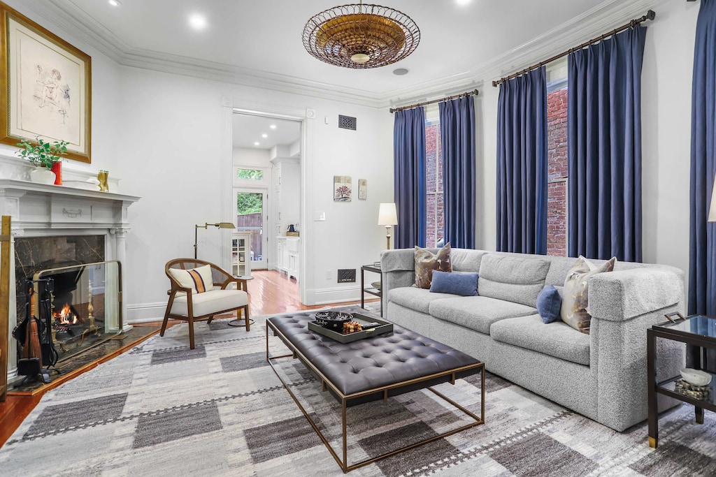 Secondary seating area next to the kitchen with a decorative fireplace, art, and large windows. 