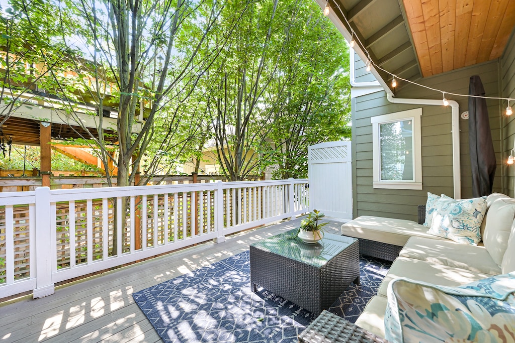 Unwind on the shaded private patio with lush greenery and cushioned seating—a peaceful downtown retreat.