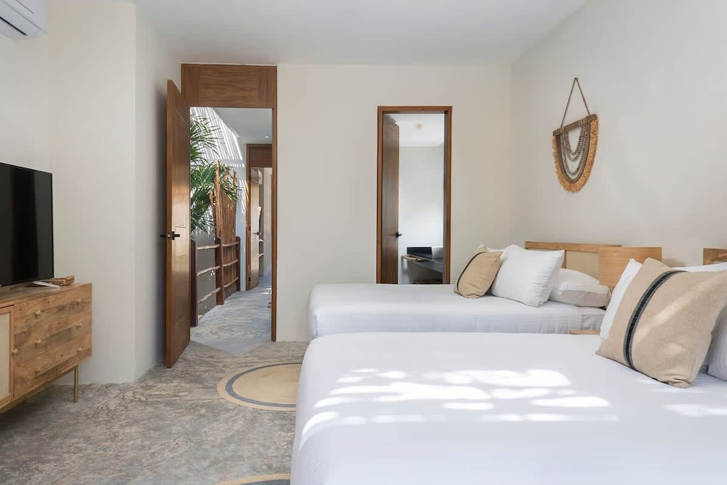 Spacious and bright room with two double beds. It includes a TV and a private bathroom.