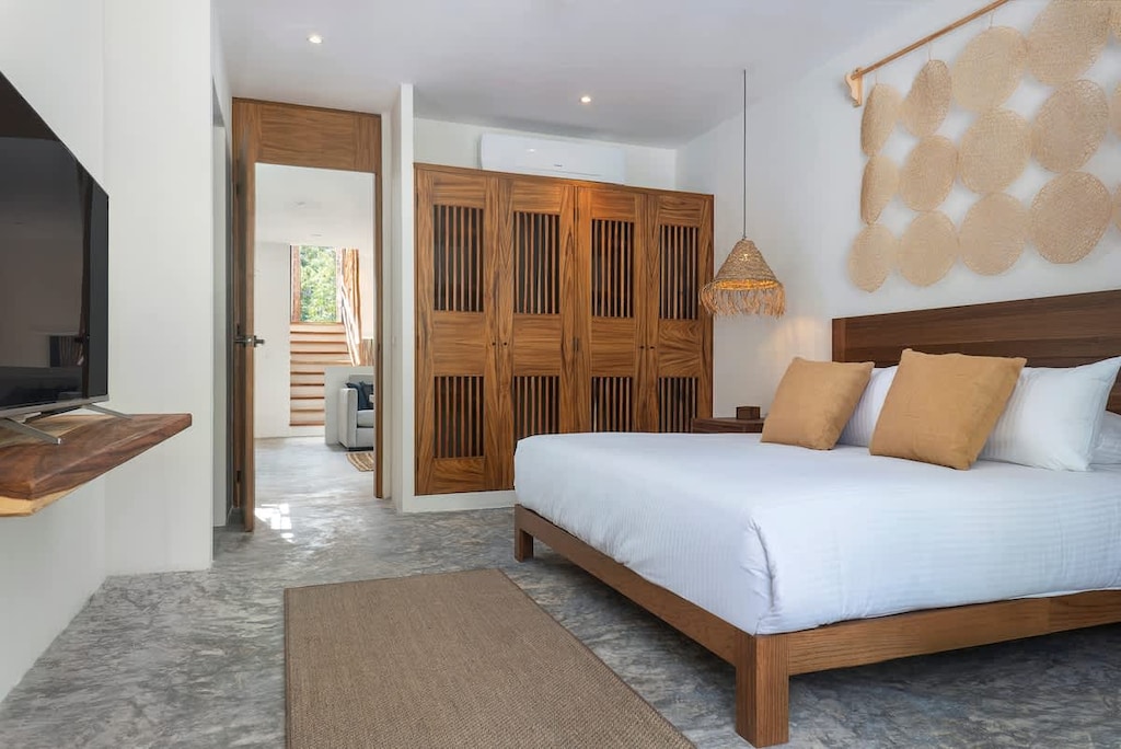 Spacious room with a king-size bed. It has a TV, AC, and storage closets.