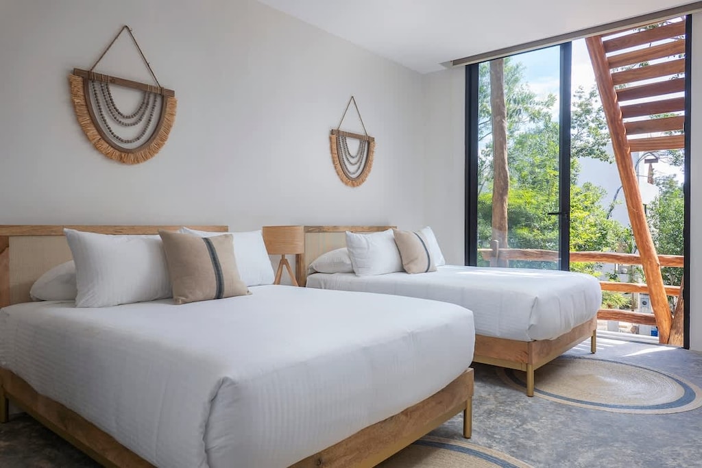 Spacious room with two double beds. Views of the exterior.