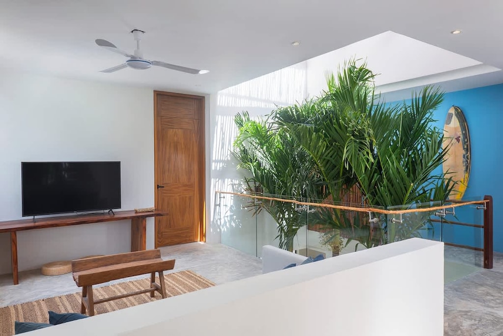 Comfortable living room located on the second floor. It includes a sofa bed, TV, and ceiling fan.
