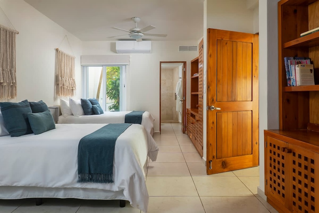 Beautiful room with two single beds. It has AC, a ceiling fan, and a bathroom.