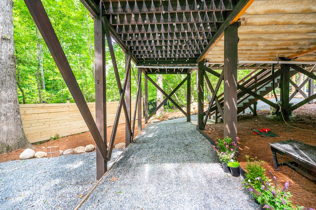 Follow the gravel path beneath the treehouse-style structure for a peaceful walk from the driveway to your galaxy getaway.
