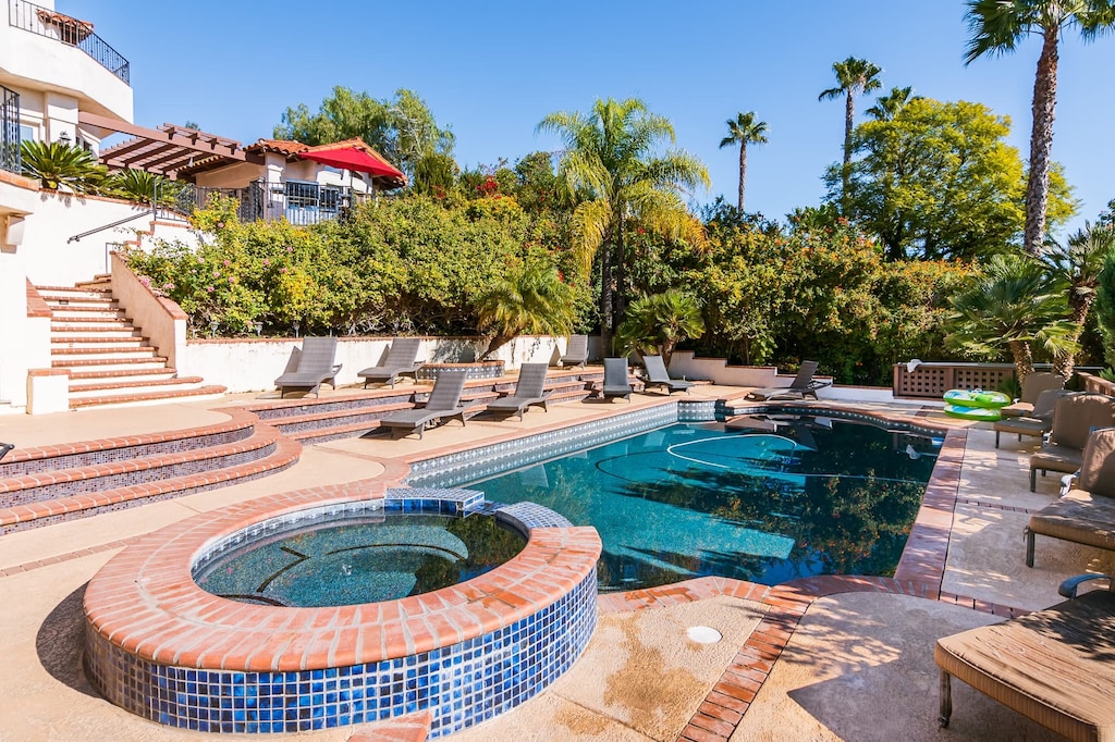 Escape the everyday with a private pool and jacuzzi, surrounded by lush landscaping.