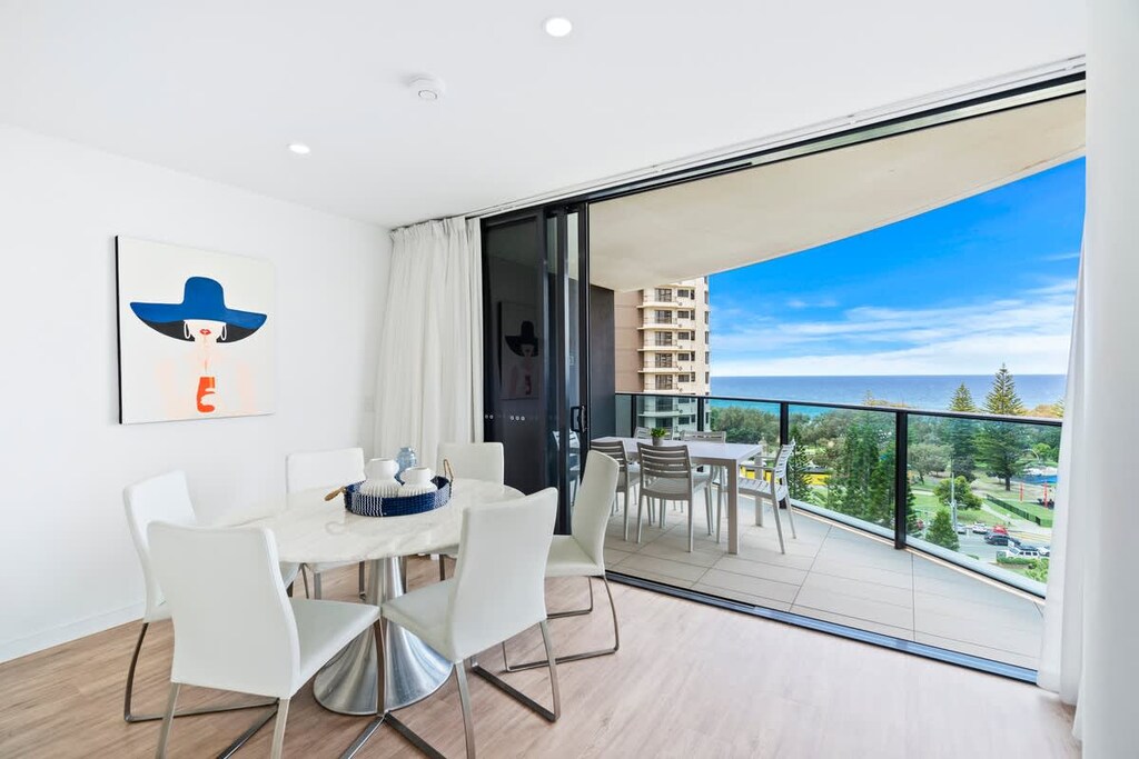 Bright dining area with large sliding doors onto the balcony for a summer breeze. 