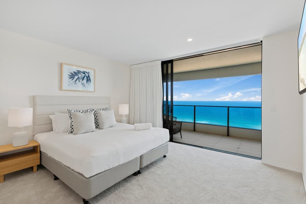 Master bedroom with a coastal style and stunning views of the ocean. 