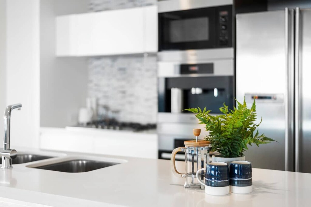 Modern, bright kitchen with European appliances and stone countertops.