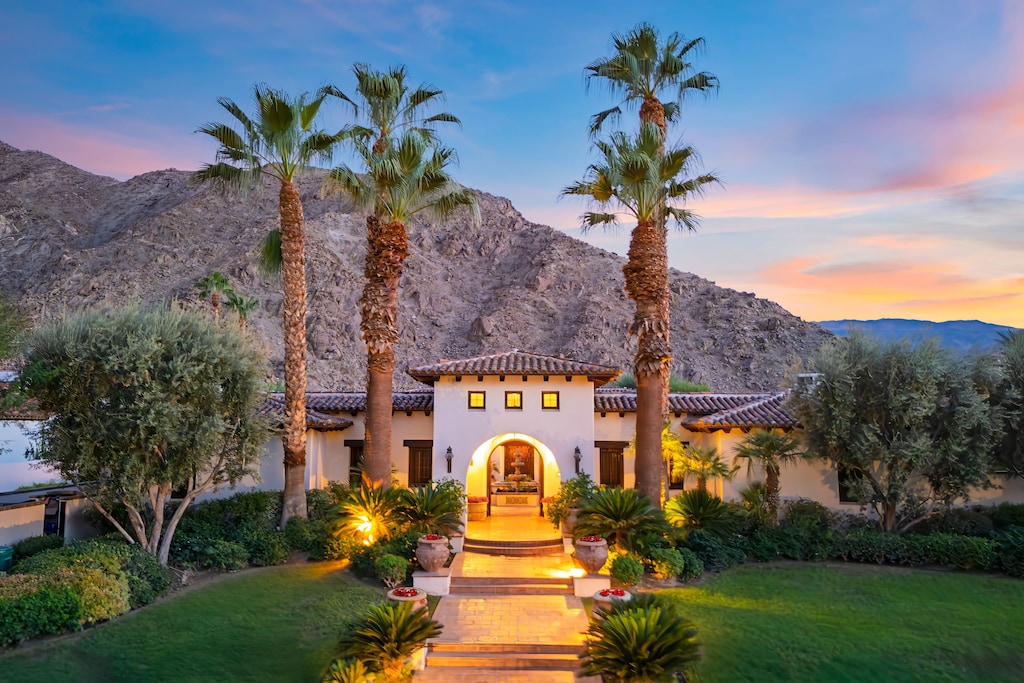 Sunset at this beautiful Mediterranean-style home, nestled at the base of a majestic mountain.