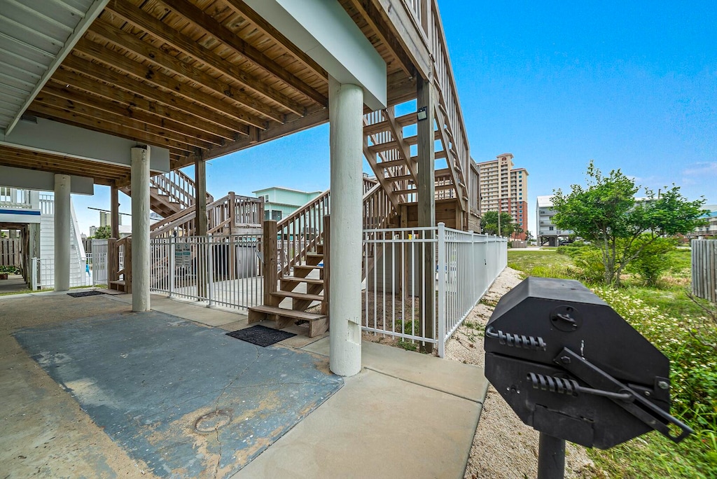Relax in this outdoor space featuring a charcoal grill and easy access to the nearby stairs and lush greenery