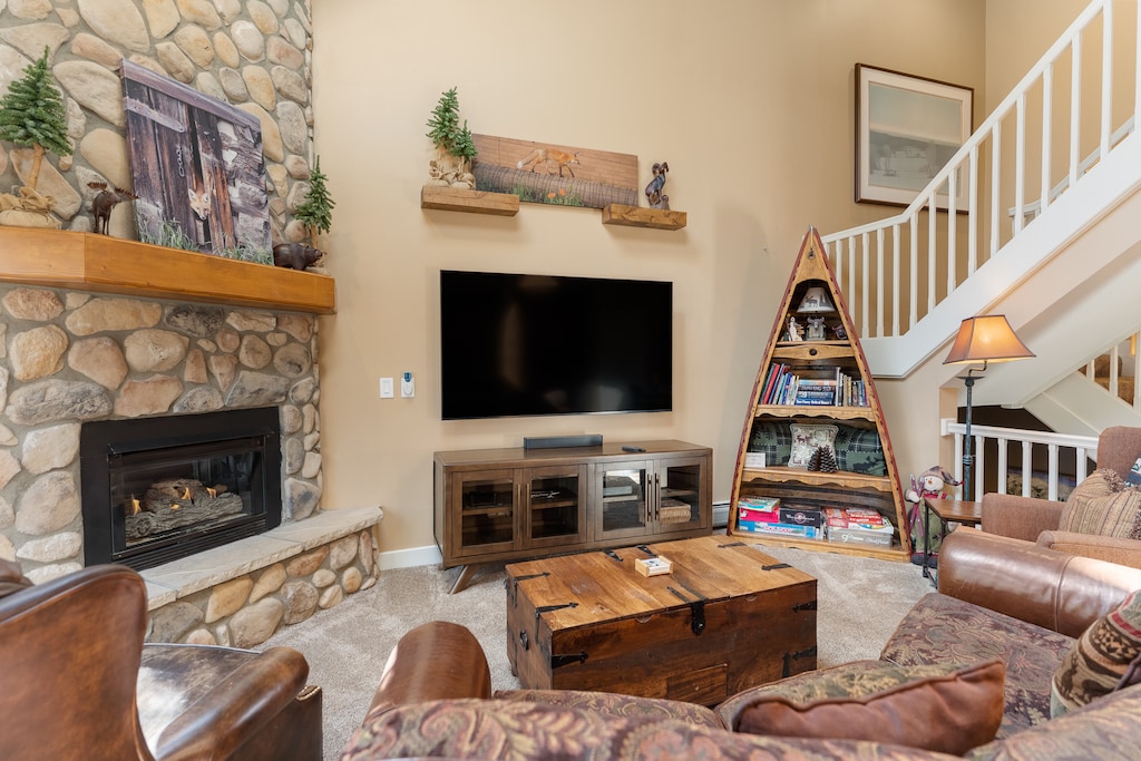 The living area features a flat-screen TV, and a fireplace. 
