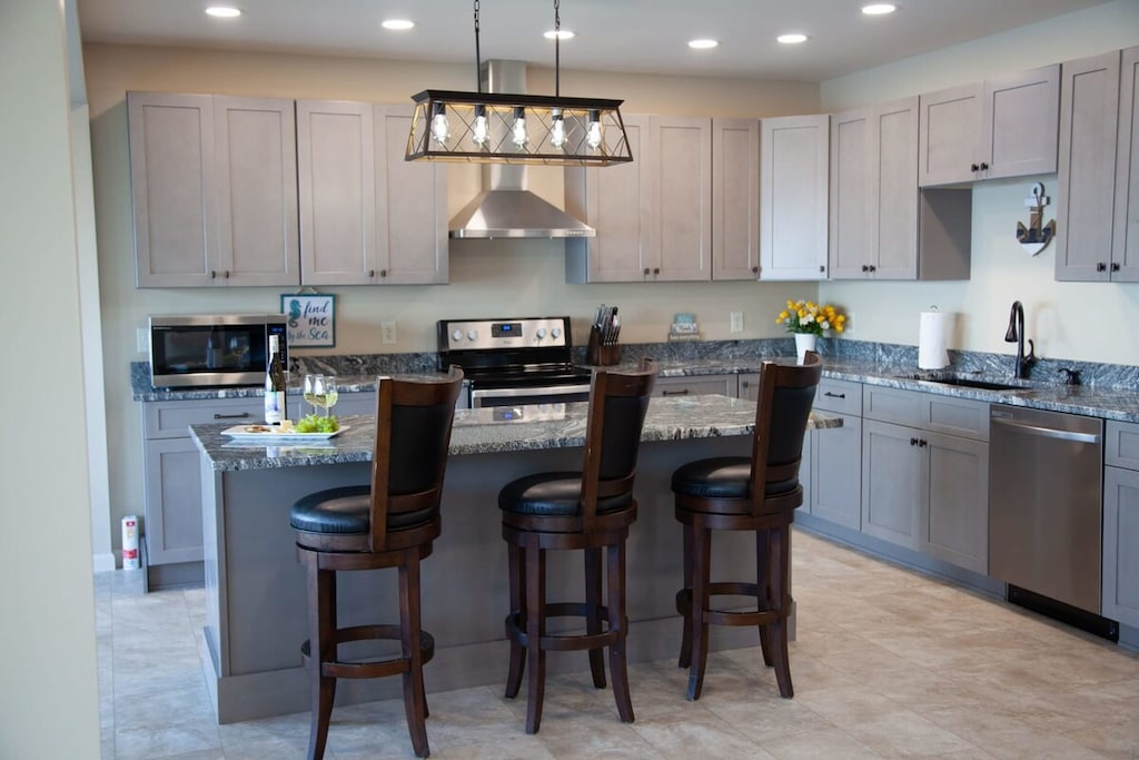 Kitchen- Fully stocked kitchen with modern appliances and breakfast bar seating.