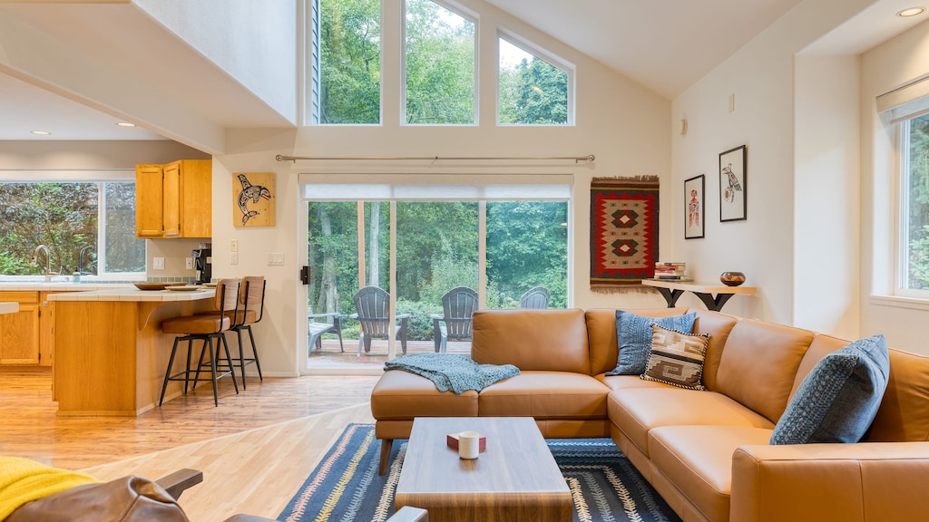 Bright living room with vaulted ceilings and large windows.