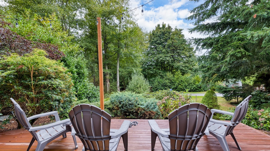 Outdoor deck with seating among trees.