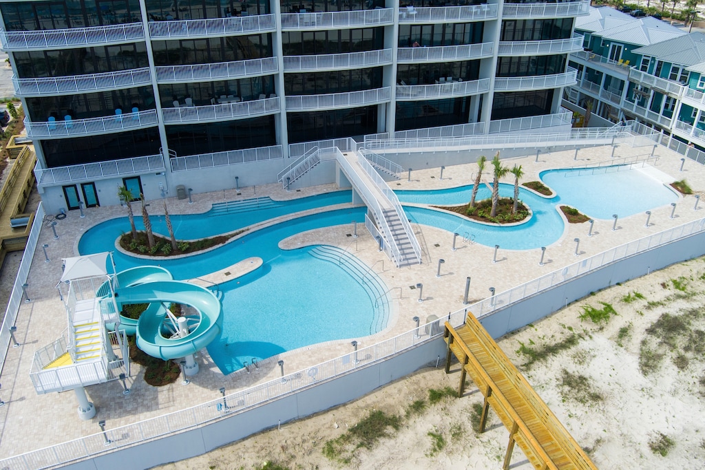 Dive into fun at the pool area featuring a lazy river and waterslide, just steps to the beach at Phoenix Gulf Shores II