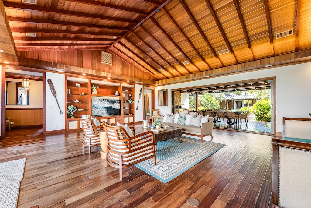 Step into the grand great room, where open-beam ceilings and floor-to-ceiling windows invite ocean breezes.