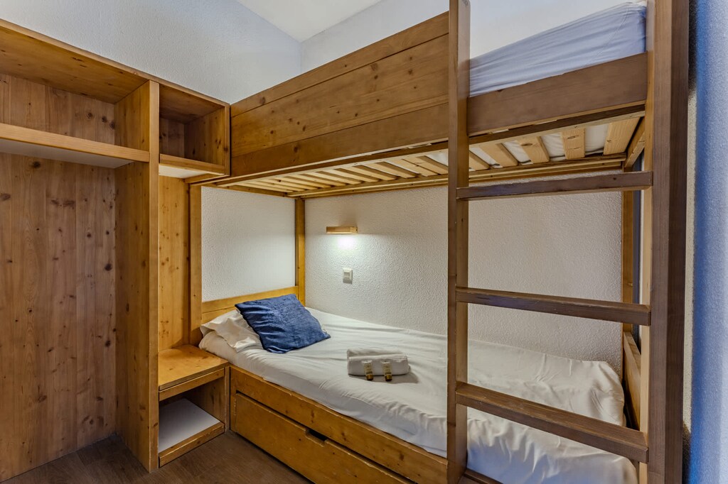 Rest easy in your wooden alpine-style bunk beds — perfect for families or friends looking for a warm, authentic mountain stay.