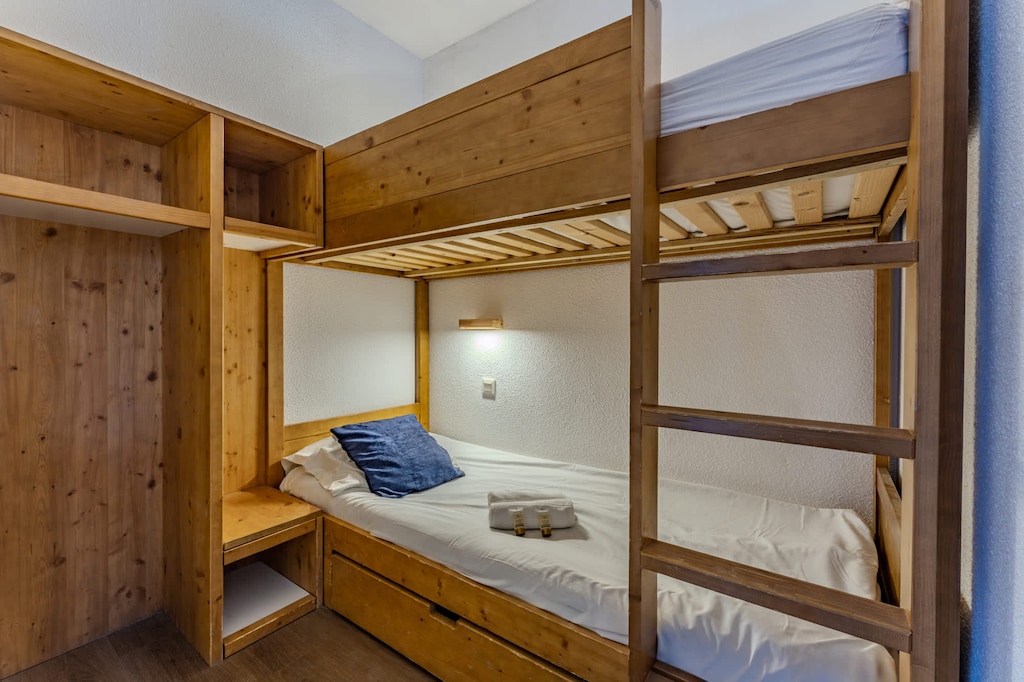 Rest easy in your wooden alpine-style bunk beds — perfect for families or friends looking for a warm, authentic mountain stay.