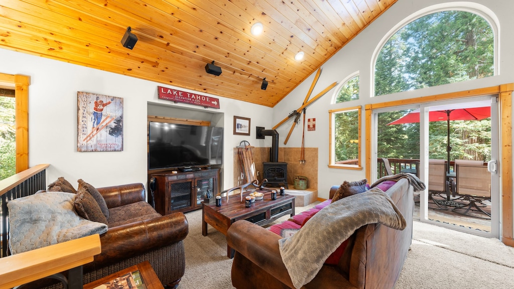 The living room features cozy seating, TV, fireplace, and easy access to the balcony.