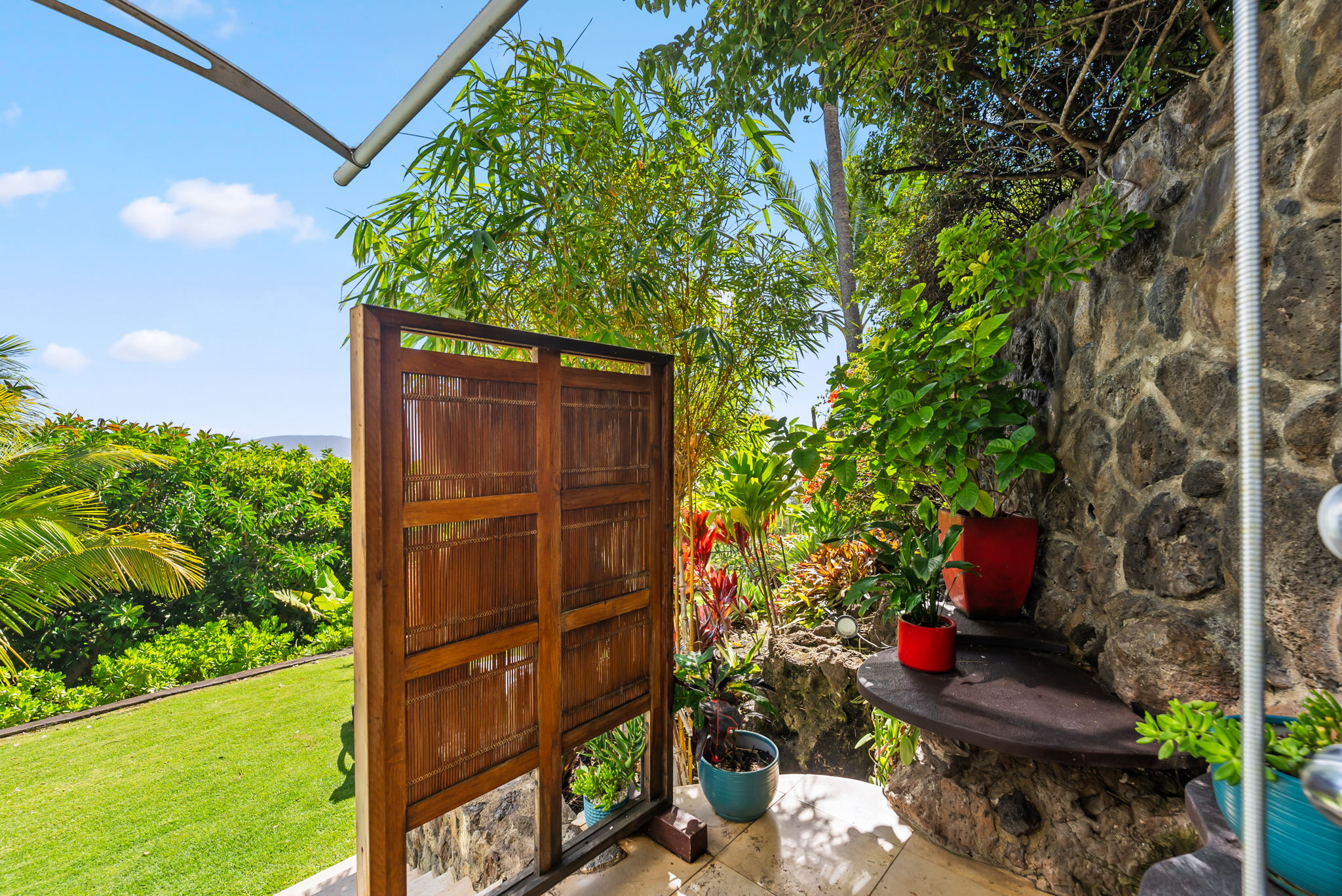 Surrounded by greenery, this open-air shower offers a refreshing, nature-connected experience.