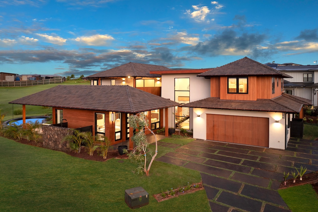 Aerial view of the private estate surrounded by greens and ocean horizon.