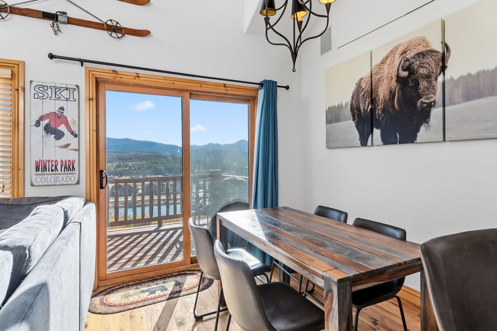 Your mountain getaway dining space features rustic charm with breathtaking valley views through sliding glass doors to your private balcony.