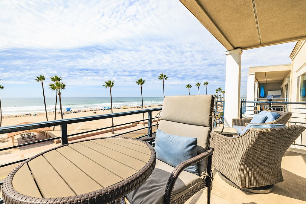 The spacious balcony includes a small table with two chairs, plus two swivel chairs for relaxing.
