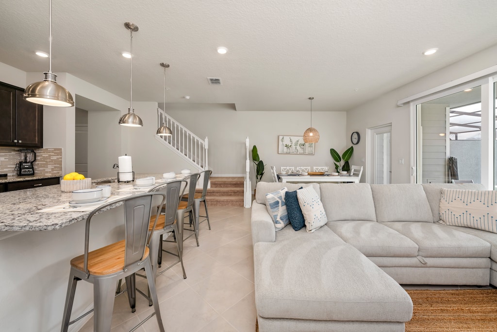 The living room, kitchen, and dining area seamlessly blend into one open space, creating the perfect setting for socializing during the holidays.