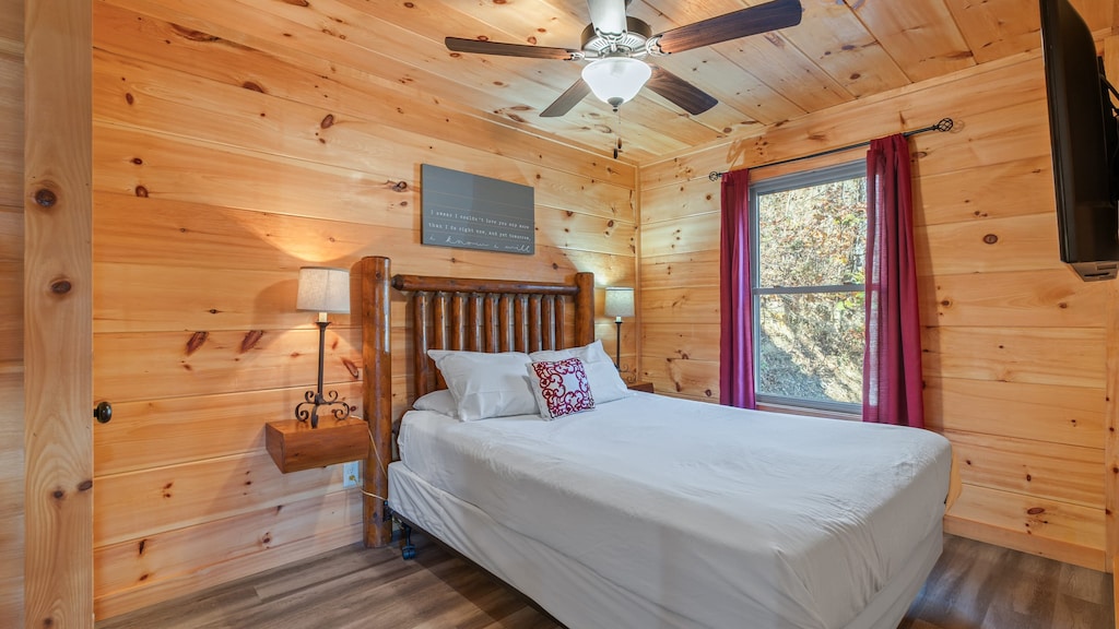 The bedroom features a queen bed and a TV.