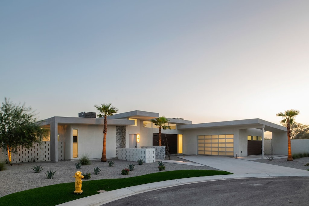 The striking, modern architectural facade of the home welcomes you to your luxury Indio getaway at sunset.