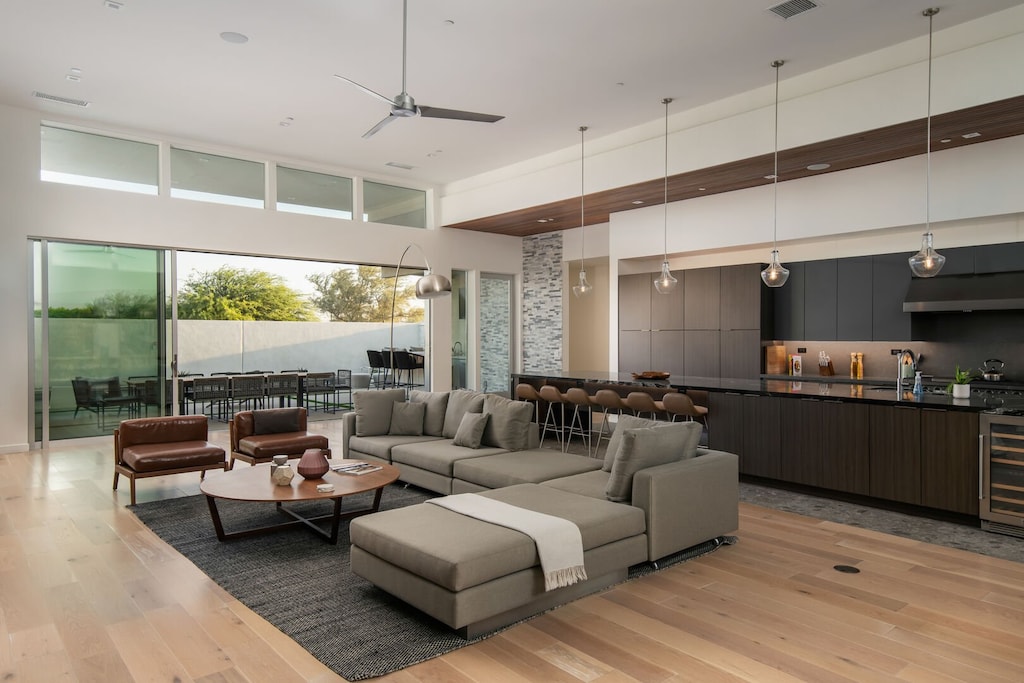 The stunning open-concept design connects the gourmet chef's kitchen, featuring a black marble island and warm wood ceilings, to the comfortable living area.