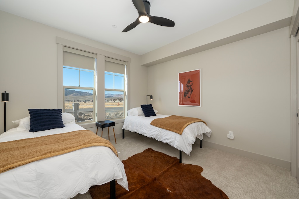 Drift off peacefully in this bright twin bedroom, where comfortable beds and stunning mountain views create your perfect retreat.