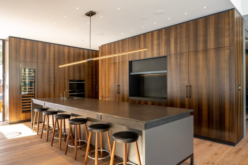 - Sleek kitchen with rich wood finishes and stone countertops  
- Spacious island with bar seating for casual dining and gatherings  
- Modern appliances designed for style and functionality  