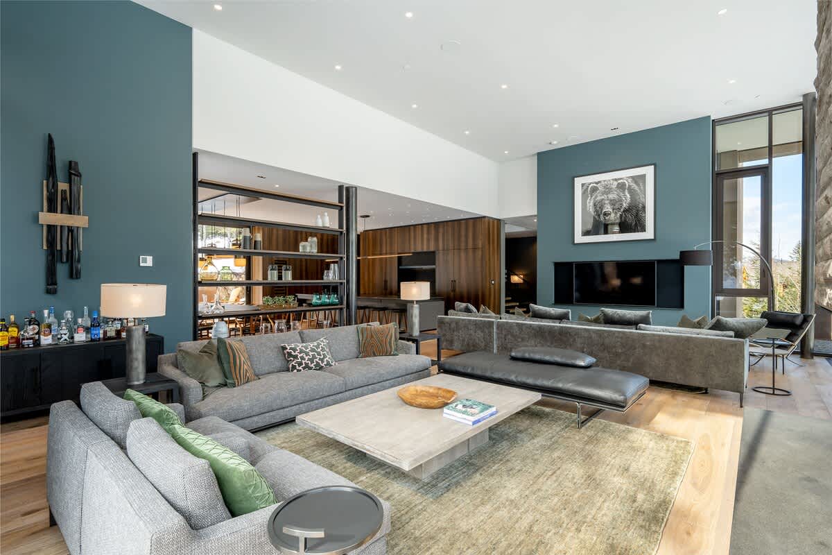 - Expansive living room with bold color tones and open design  
- Modern furniture centered around a stylish stone fireplace  
- Perfect for entertaining or relaxing after skiing adventures  