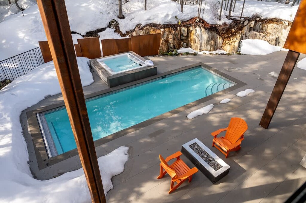 - Heated outdoor pool and spa surrounded by fresh snow  
- Firepit with Adirondack chairs for evening relaxation  
- Mountain air and tranquil forest views create a serene retreat  
