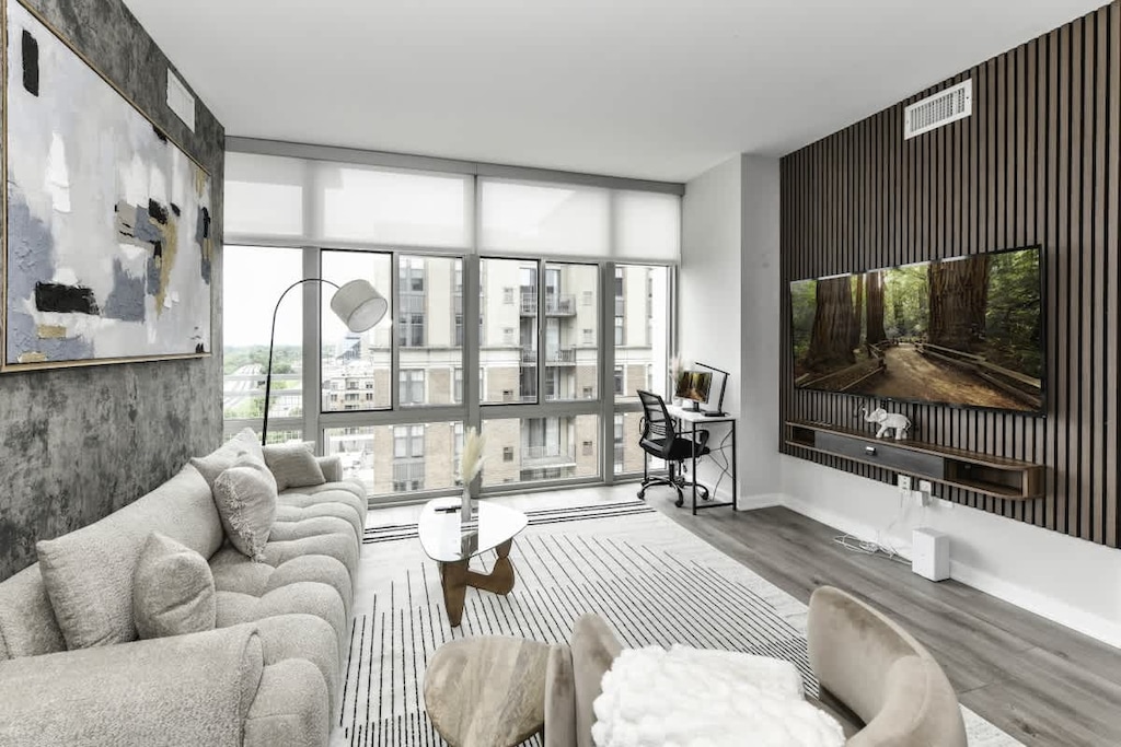 Chic and bright living room with cozy couch, flatscreen Tv and dedicated work station