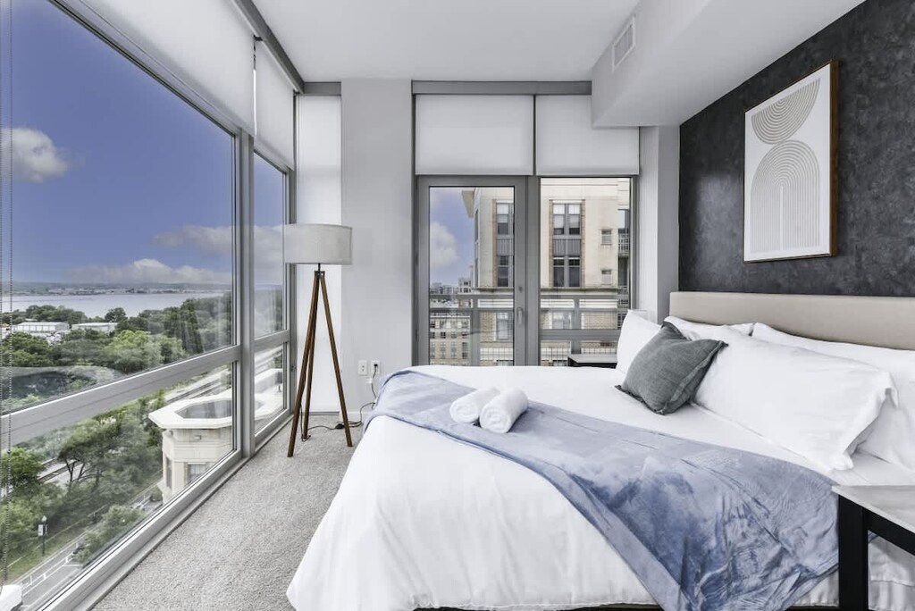 Runway Views ✈️ Relax in a modern king bedroom with floor-to-ceiling windows to watch planes land & take off right from your bed!