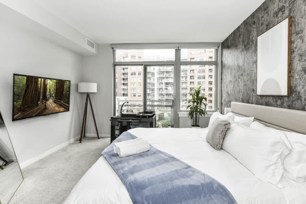 Bedroom 1 with cozy king bed, pack n play crib, flat-scrteen TV and large windows