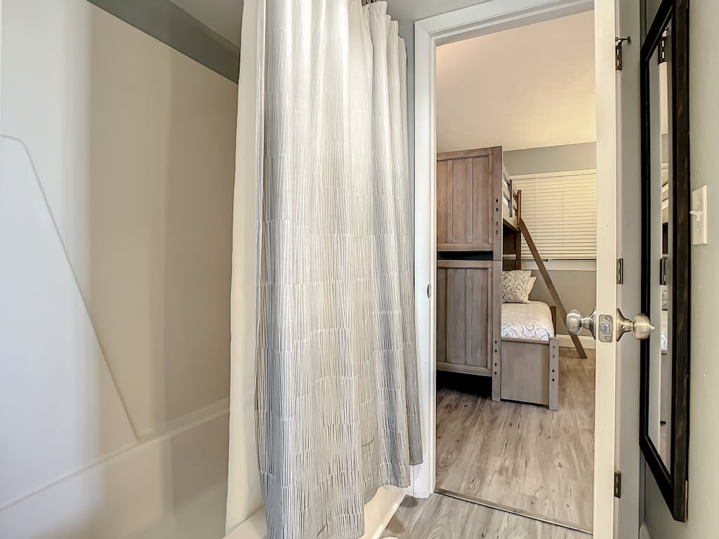 Clean and functional bathroom seamlessly connected to a cozy bunk bed space.