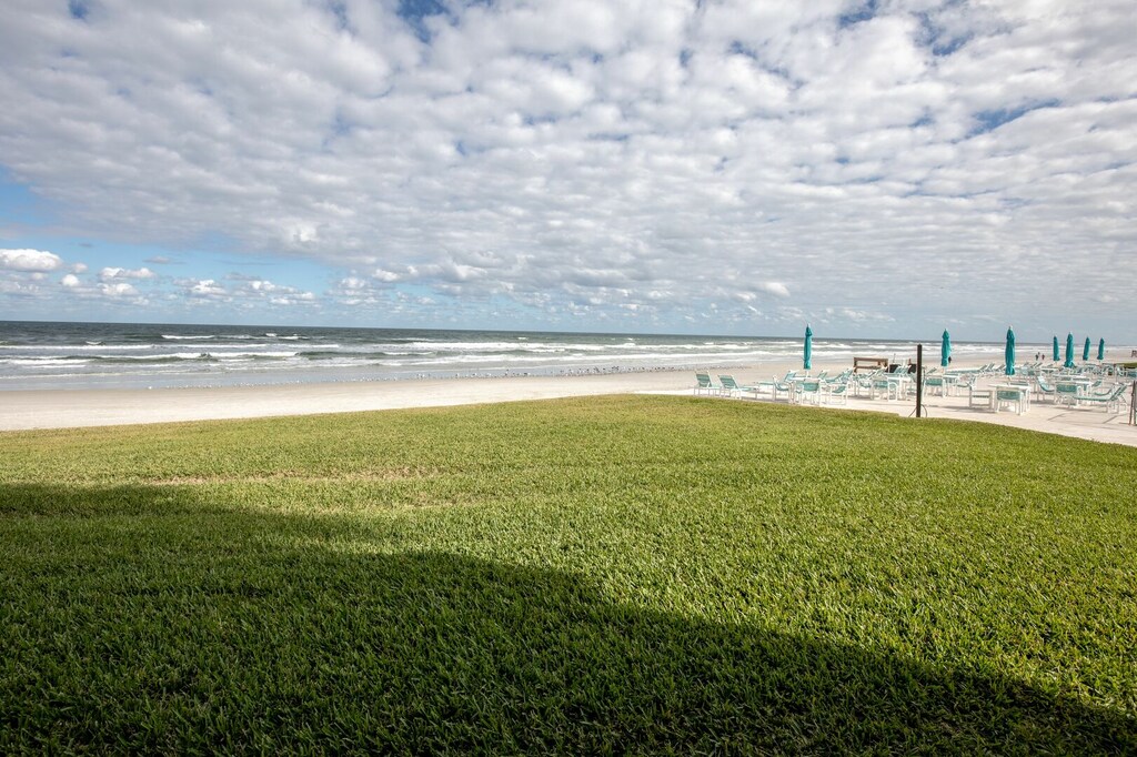 Step outside to a wide stretch of sandy beach with lounge chairs and umbrellas ready for relaxation. Perfect for soaking up the sun, ocean breezes, and unforgettable beach vacation memories.