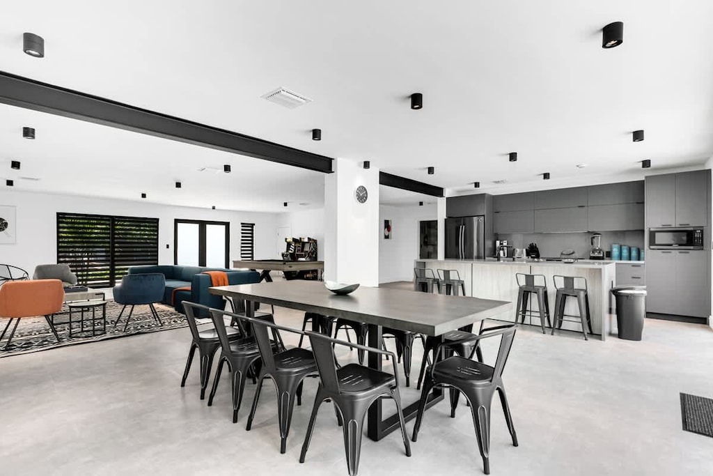  a huge dining table, stylish bar seating, and modern kitchen. Ideal vacation rental for group getaways, family dinners, and hosting friends in a relaxed, contemporary space.