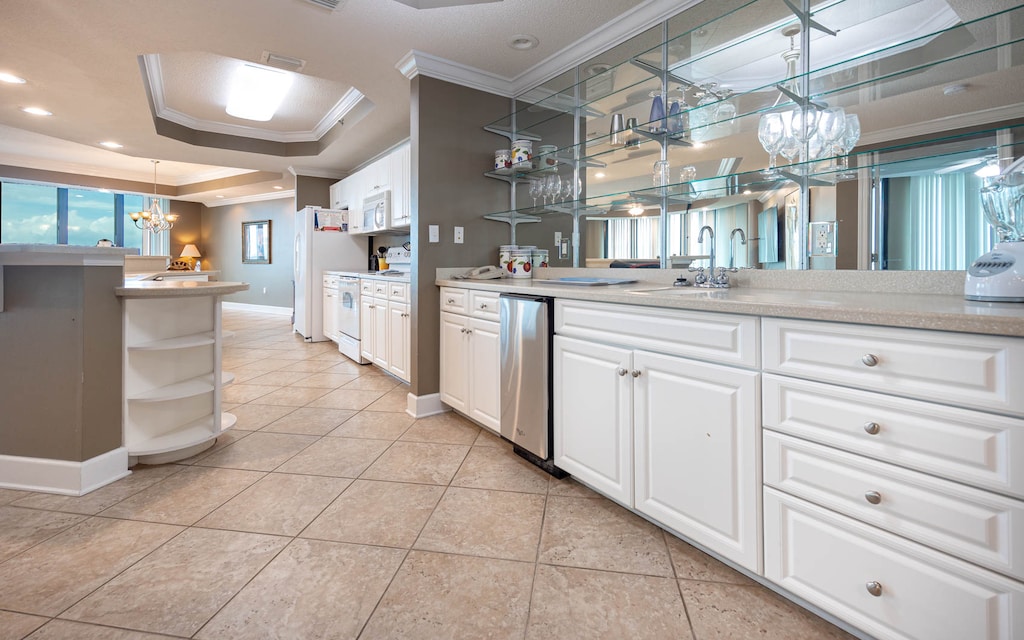 Kitchen and wet bar area featuring white cabinetry, a glassware display, and spacious countertops