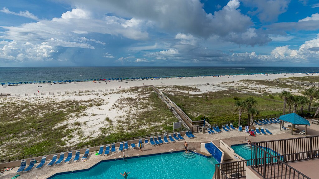 Enjoy the inviting pool area with lounge chairs, offering easy access to the beach and beautiful coastal views