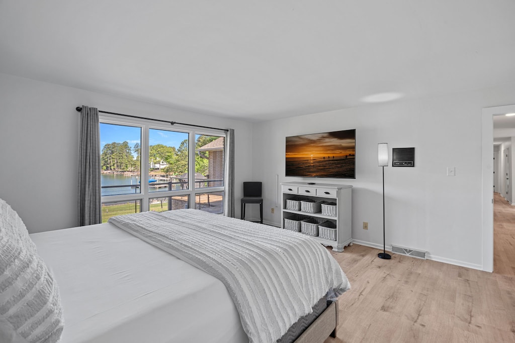 Primary suite with king bed, TV, full bath and lake views.