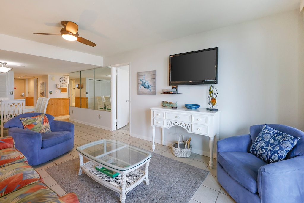 Living area featuring comfortable seating, queen sofa-sleeper, a flat-screen TV, and coastal-inspired decor