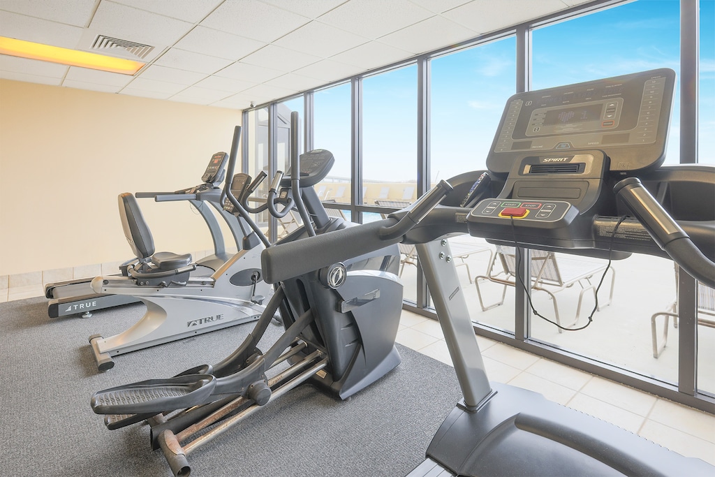Stay fit in the Phoenix IV gym with views of the pool and beach, featuring modern equipment for your workout routine